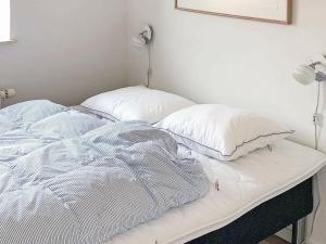 an unmade bed with two pillows on top of it at Holiday Home Banedæmningen II in Hejls