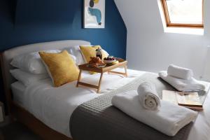 a white bed with towels and a table on it at Hinksey Heights in Oxford