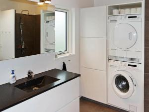 a kitchen with a washing machine and a sink at 10 person holiday home in Hadsund-By Traum in Nørre Hurup