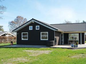 a black house with a yard in front of it at 10 person holiday home in Hadsund-By Traum in Nørre Hurup