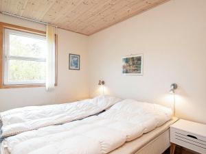 a large white bed in a room with a window at 6 person holiday home in Læsø-By Traum in Læsø