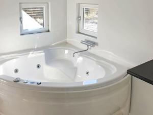 a white bath tub in a bathroom with two windows at 8 person holiday home in Hals in Hals