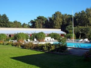 a swimming pool with lounge chairs in a yard at 4 person holiday home in Nex in Strandby Gårde
