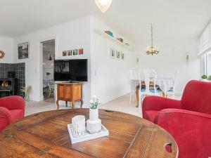 sala de estar con mesa de madera y sillas rojas en 6 person holiday home in Ulfborg en Ulfborg