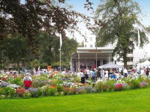 una multitud de personas de pie alrededor de un jardín con flores en 4 person holiday home in LYSEKIL en Brastad