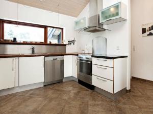 a kitchen with white cabinets and stainless steel appliances at 8 person holiday home in Dannemare in Dannemare