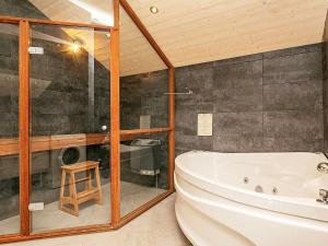 a bathroom with a tub and a shower and a stool at 8 person holiday home in Dannemare in Dannemare
