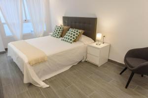 Łóżko lub łóżka w pokoju w obiekcie Apartamentos Constitución by Renthas