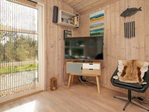 Jerupにある5 person holiday home in Jerupのテレビ、椅子、デスクが備わる客室です。
