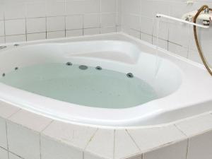 y baño con bañera de agua azul. en 8 person holiday home in Hj rring en Kærsgård Strand
