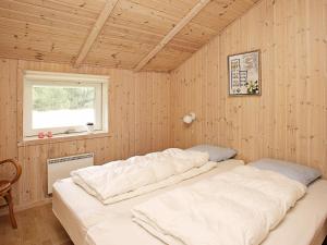 a large white bed in a room with a window at 5 person holiday home in lb k in Ålbæk