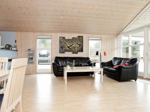 uma sala de estar com dois sofás de couro preto e uma mesa em 6 person holiday home in Dannemare em Dannemare