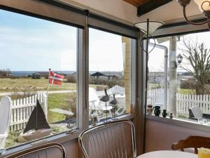 4 person holiday home in Snedsted في Snedsted: شاشة في الشرفة مطلة على المحيط