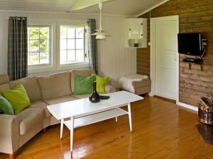 un soggiorno con divano e tavolo di Two-Bedroom Holiday home in Utvik 2 a Reed