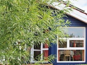 ein blaues Haus mit einem Baum davor in der Unterkunft 6 person holiday home in Otterndorf in Otterndorf