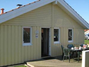 a small yellow house with a table and chairs at 12 person holiday home in Otterndorf in Otterndorf