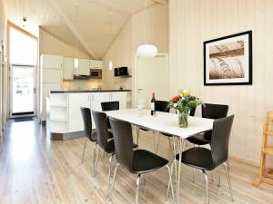 cocina y comedor con mesa blanca y sillas en Three-Bedroom Holiday home in Großenbrode 6, en Großenbrode