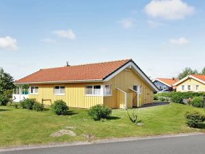 ein gelbes Haus mit rotem Dach in der Unterkunft 6 person holiday home in Otterndorf in Otterndorf
