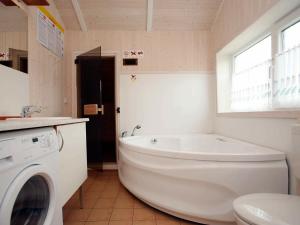 ein Badezimmer mit einer Badewanne und einer Waschmaschine in der Unterkunft 6 person holiday home in Otterndorf in Otterndorf