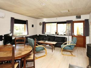 Ålbækにある6 person holiday home in lb kのリビングルーム(ソファ、テーブル、椅子付)