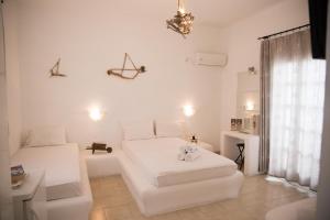 Cette chambre blanche dispose d'un lit et d'un canapé. dans l'établissement Villa Garden, à Fira 23 autres photos