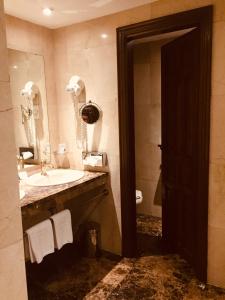 a bathroom with a sink and a toilet and a mirror at Parador de Santillana del Mar in Santillana del Mar
