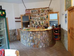 eine Bar in einem Zimmer mit einer Steinmauer in der Unterkunft Къща за гости Камината in Trigrad