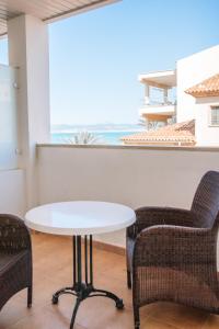 uma mesa e cadeiras num quarto com vista para o oceano em Q-Royal em Playa de Palma