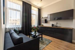 a living room with a couch and a kitchen at Beautiful apartment in the heart of Kaunas in Kaunas
