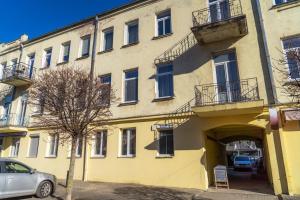 a yellow building with an archway in front of it at Beautiful apartment in the heart of Kaunas in Kaunas