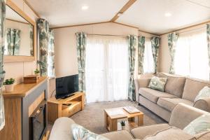 a living room with a couch and a tv at Yorkshire Lodge with Hot Tub in York