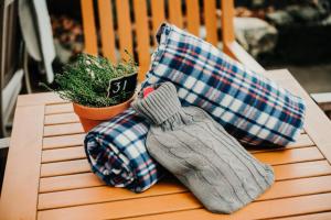 a pair of mittens and pillows on a wooden bench at Inn in the Park in Bournemouth