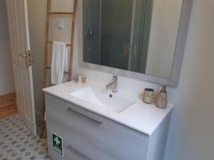 y baño con lavabo blanco y espejo. en Sintra Lux Home en Sintra