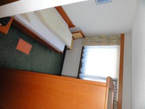 Schlafsaal mit einem Bett und einem Fenster in der Unterkunft Hotel Tannenboden - Steinbock in Flumserberg