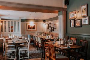 a restaurant with wooden tables and chairs in a room at Inn in the Park in Bournemouth