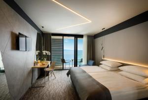 a hotel room with a large bed and a desk at Hotel Istra - Liburnia in Opatija