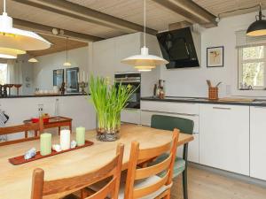 cocina y comedor con mesa de madera en 6 person holiday home in Bl vand, en Blåvand