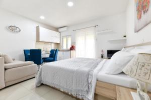 Biała sypialnia z łóżkiem i kuchnią w obiekcie Apartments Diora w mieście Seline