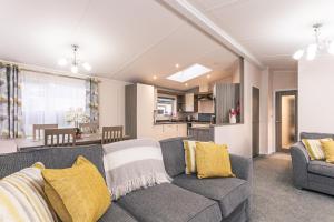 a living room with a couch and a kitchen at Woodpecker Lodge with Hot Tub in York