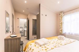 a bedroom with a bed and a desk and a sink at Woodpecker Lodge with Hot Tub in York