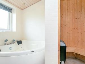 y baño con bañera blanca y lavamanos. en 8 person holiday home in Faaborg, en Bøjden