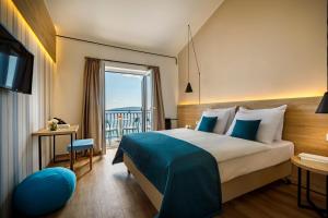 ein Hotelzimmer mit einem Bett und einem Balkon in der Unterkunft Hotel Mediteran - Liburnia in Mošćenička Draga
