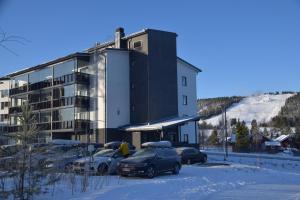 un estacionamiento con autos estacionados frente a un edificio en Tahko Spa Hotel en Tahkovuori