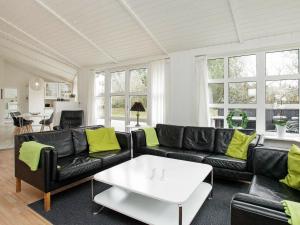 Grønhøjにある10 person holiday home in L kkenのリビングルーム(黒い革張りのソファ、テーブル付)