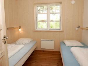 two beds in a room with a window at Modern Holiday Home in Aakirkeby with Sauna in Vester Sømarken