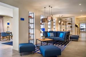 a living room with a blue couch and a table at Hotel Mediteran - Liburnia in Mošćenička Draga