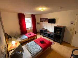 Habitación pequeña con 2 camas y TV. en Ferienwohnungen by K Krause en Salzgitter