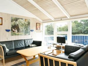 a living room with a couch and a table at 10 person holiday home in lb k in Skram