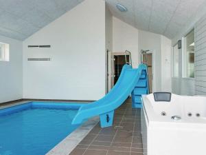 een zwembad met een blauwe glijbaan in een huis bij 20 person holiday home in Glesborg in Glesborg
