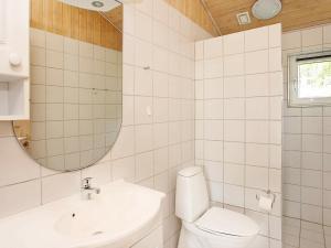 a bathroom with a toilet and a sink and a mirror at Seaside Haven Retreat - By Traum Ferienwohnungen in Skram +24 photos